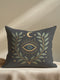 A luxury linen-feel dark gray pillow by Grimoire and Goblet, complete with insert. Features a central, embroidered-look All-Seeing Eye in blue and gold, surrounded by a radiant golden laurel wreath, crescent moon, and stars. Mystical gothic pillow with a seamless zipper.