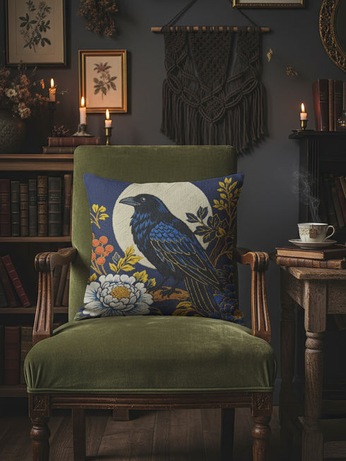 Grimoire and Goblet pillow cover featuring a black raven perched on vintage leather books. The design uses a faux embroidery effect printed on smooth premium polyester fabric. Dark academia aesthetic with moody navy, sepia, and gold tones. Detail shows linen-like texture of the fabric and the hidden zipper closure. Perfect for gothic home decor, reading nooks, or library accents.