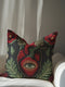 A black square pillowcase cover featuring a central anatomical heart in crimson red. Inside the heart is a large, detailed green eye surrounded by a golden sunburst. The heart is framed by lush green leaves and deep red poppy flowers. This trompe-l'œil print by Grimoire and Goblet creates a realistic embroidered illusion. Perfect for gothic or dark academia styling, the design combines medical illustration with mystical symbolism.