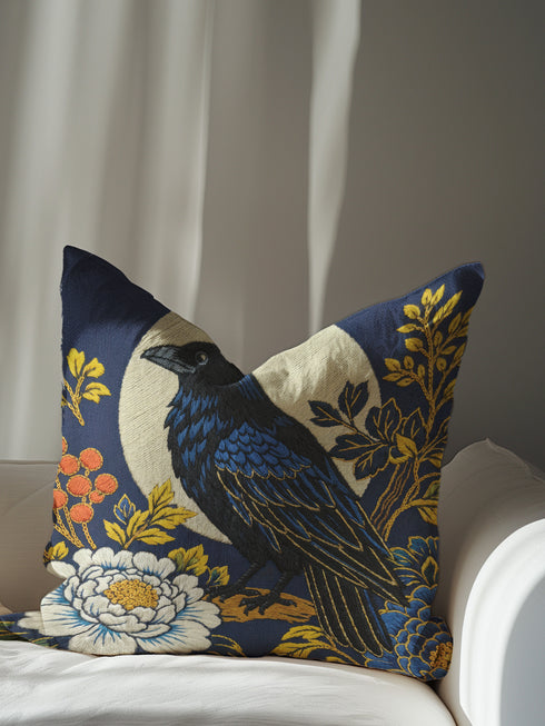 Grimoire and Goblet pillow cover featuring a black raven perched on vintage leather books. The design uses a faux embroidery effect printed on smooth premium polyester fabric. Dark academia aesthetic with moody navy, sepia, and gold tones. Detail shows linen-like texture of the fabric and the hidden zipper closure. Perfect for gothic home decor, reading nooks, or library accents.