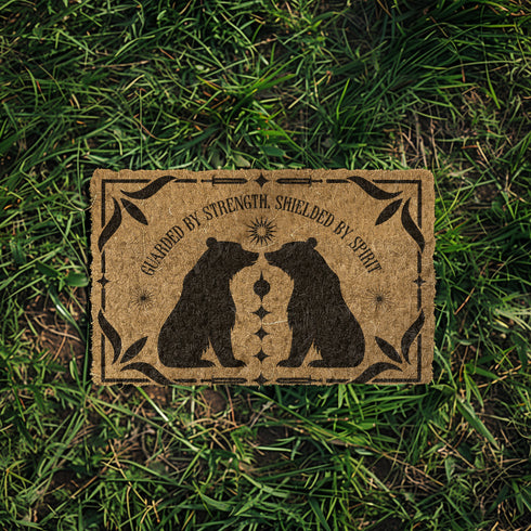 Natural coir doormat featuring two black bear silhouettes facing each other, surrounded by botanical and celestial accents. The mat is made from eco-friendly coir fiber with a slip-resistant vinyl backing, ideal for outdoor use in covered entryways.