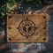 Natural tan coir doormat with large Algiz rune symbol inside an ornate compass design, surrounded by runic-inspired border elements, all in dark brown.