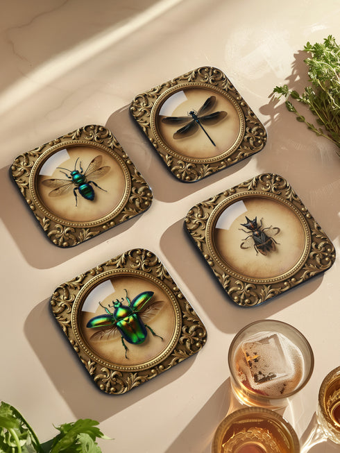 Set of four luxury coasters featuring taxidermy inspired specimen entomology art, showcasing detailed illustrations of beetles and dragonflies encapsulated within ornate, gold baroque frames. The square drink coasters are crafted from masonite hardboard with a waterproof high-gloss finish, protecting delicate surfaces during dining rituals. Essential gothic barware, complementing any fine cocktail, esoteric tea, or wine served in a Goblet. A premium curio cabinet accent by Grimoire and Goblet.