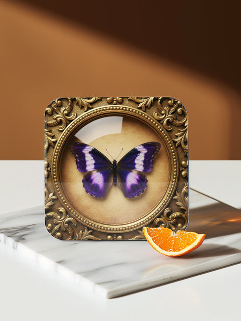Grimoire and Goblet offers this luxury four-piece square Coaster Set featuring glossy, dome-covered, Taxidermy-inspired Entomology butterfly specimens, framed in ornate Victorian Gothic style. The resilient hardboard foundation and non-slip cork backing provide premium, waterproof protection for fine cocktails and esoteric teas. The collection includes purple, green, white, and peacock butterfly art, ideal for Dark Academia, Oddity, and Curio Cabinet decor.