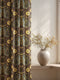 Grimoire and Goblet blackout curtains featuring a repeating Death's Head Moth pattern. The design utilizes a trompe-l'œil effect to mimic raised gold embroidery on a deep espresso brown background. The moths feature skull thoraxes and slate blue wings, surrounded by antique gold peonies and vines in a symmetrical damask layout. The fabric is a smooth, satiny heavyweight polyester with a white reverse side, offering light-blocking functionality.
