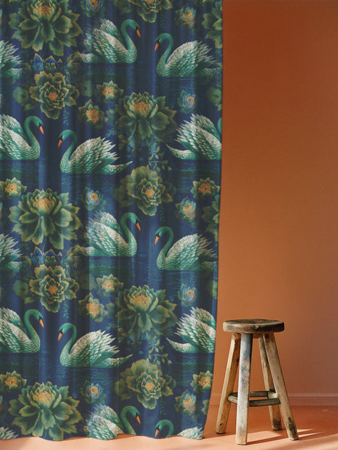 Grimoire and Goblet blackout curtain panel featuring a repeating Art Nouveau pattern of regal white swans and lush emerald green peonies on a deep midnight navy blue background. The design includes floating lily pads and stylized floral foliage with hints of ochre gold. The fabric is 100% heavyweight polyester with a satin finish and a rod pocket header. The print mimics the look of vintage embroidery but is a smooth, high-quality flat print.