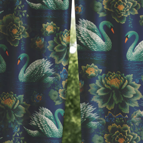 Grimoire and Goblet blackout curtain panel featuring a repeating Art Nouveau pattern of regal white swans and lush emerald green peonies on a deep midnight navy blue background. The design includes floating lily pads and stylized floral foliage with hints of ochre gold. The fabric is 100% heavyweight polyester with a satin finish and a rod pocket header. The print mimics the look of vintage embroidery but is a smooth, high-quality flat print.
