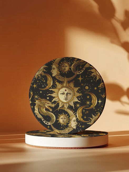 A round ceramic coaster featuring a dark navy background with golden celestial design elements: baroque-style sun faces, crescent moons with feminine profiles, stars, and a mystical dragon. The pattern is rendered in metallic gold tones, creating a rich, ornate astronomical motif.