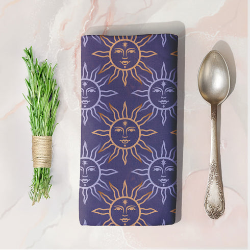 Four-piece cloth napkin set with celestial sun motifs in gold and silver on a deep navy background, made of durable, lint-resistant polyester.