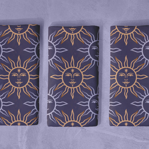 Four-piece cloth napkin set with celestial sun motifs in gold and silver on a deep navy background, made of durable, lint-resistant polyester.