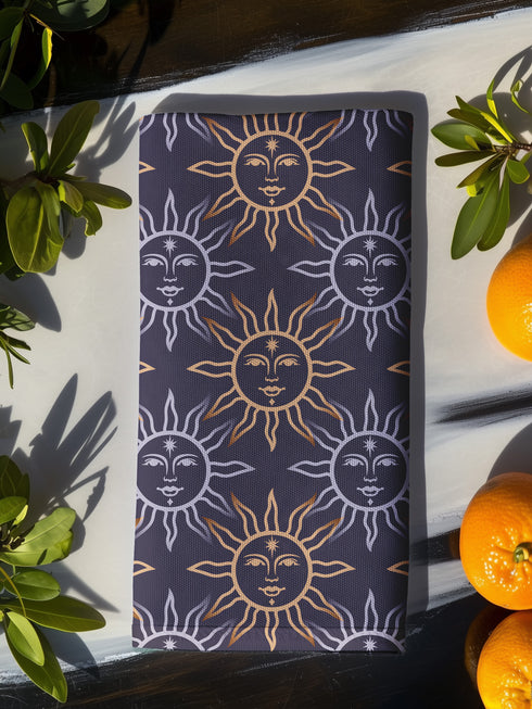 Four-piece cloth napkin set with celestial sun motifs in gold and silver on a deep navy background, made of durable, lint-resistant polyester.