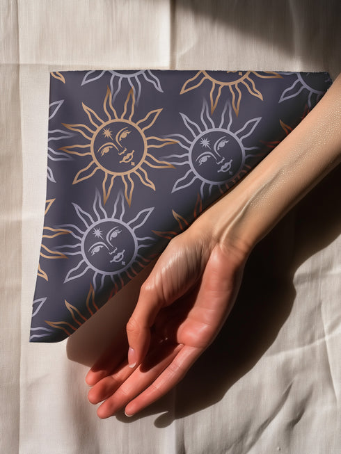 Four-piece cloth napkin set with celestial sun motifs in gold and silver on a deep navy background, made of durable, lint-resistant polyester.