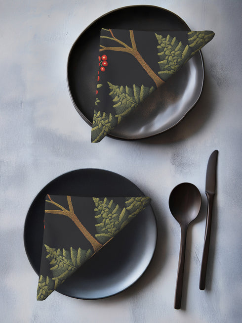 A 4-piece cloth napkin set featuring an embroidered-style illustration of a rowan tree branch with clusters of red berries and green leaves on a deep black background. Each napkin is square-shaped, made from soft polyester with a single-sided print and white reverse, perfect for mystical or autumn dining.