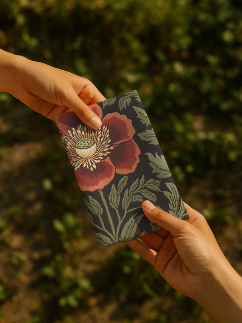 A four-piece cloth napkin set featuring oversized embroidered-style red poppy flowers with green foliage on a deep black background; square-shaped, made of soft polyester with one-sided print and white reverse.