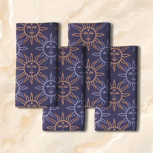 Four-piece cloth napkin set with celestial sun motifs in gold and silver on a deep navy background, made of durable, lint-resistant polyester.