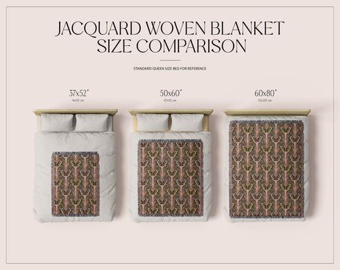 A woven cotton throw featuring an intricate luna moth pattern in bronze and muted earth tones, framed by soft fringe.