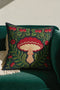 Square decorative pillow cover with a deep midnight navy ground and a symmetrical Art Nouveau botanical design rendered in a faux embroidery style. A large central mushroom anchors the composition, its scarlet ruffled cap fanning over cream and ivory gills above a pale peach stem. Curling green ferns, leafy vines, crimson flower buds, and small red blossoms frame the toadstool on every side. The printed satin-stitch detailing mimics hand-stitched thread across the entire face of the cover.