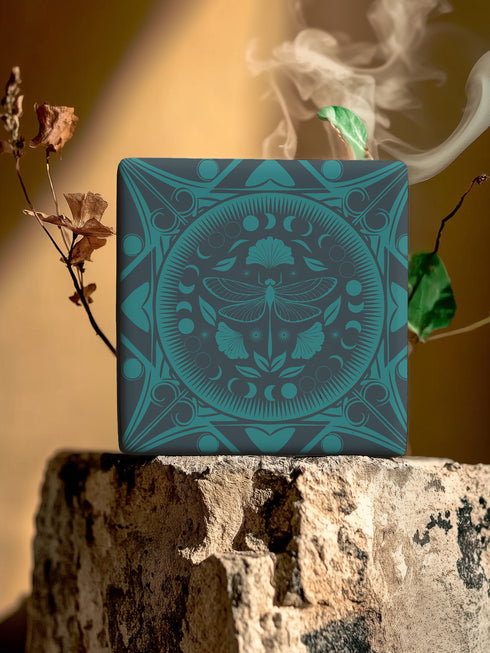 Square ceramic coaster featuring a detailed emerald green dragonfly illustration centered in a medallion, surrounded by moon phases and Art Nouveau patterns on a dark background.