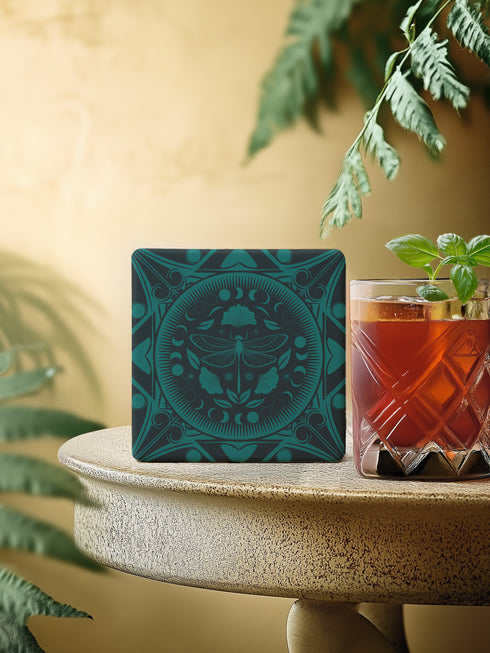 Square ceramic coaster featuring a detailed emerald green dragonfly illustration centered in a medallion, surrounded by moon phases and Art Nouveau patterns on a dark background.