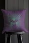 A pillow cover with a bold stag's head emerging from an ethereal burst of mint green rays against deep purple fabric. Delicate starbursts scatter around the deer, creating a celestial effect.