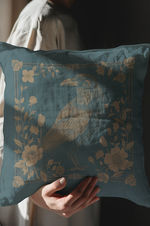 Teal throw pillow cover featuring a golden raven illustration surrounded by intricate floral designs, suitable for gothic or dark academia decor.