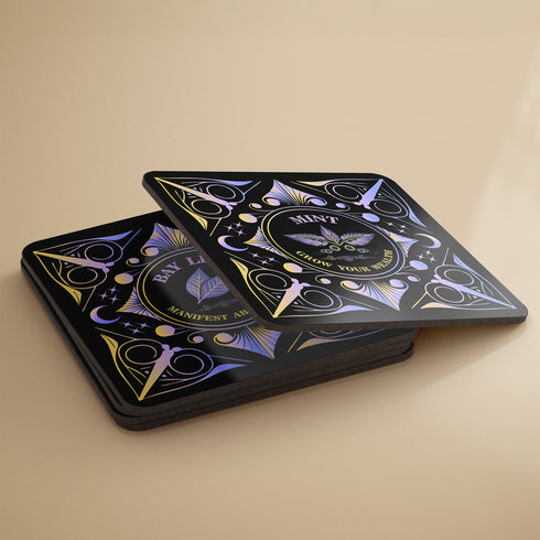 A 4-piece wealth-themed coaster set featuring intricate, gold and black designs with iridescent accents. Each coaster is dedicated to a different herb or spice, including basil, bay leaf, cinnamon, and mint, each symbolizing prosperity, abundance, riches, and wealth. The designs feature celestial motifs and geometric patterns, adding a mystical and luxurious touch to the coasters.