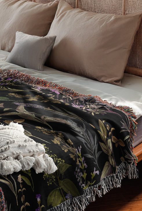 Forest green cotton throw blanket with woven silver moon phases and golden sun motifs, finished with multicolored fringe trim.