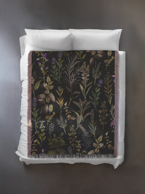 Forest green cotton throw blanket with woven silver moon phases and golden sun motifs, finished with multicolored fringe trim.