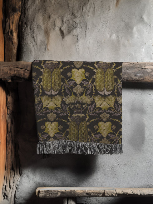 Luxurious woven cotton throw blanket featuring symmetrical scarab beetle pattern in olive green on black background with white fringe trim. Perfect for dark academia, gothic, or cottagecore decor as wall hanging or cozy throw. Mystical home gift.