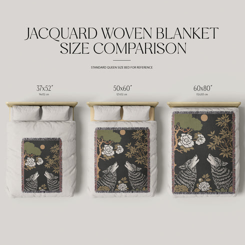 A high-contrast jacquard woven blanket featuring two wolves howling toward a central moon. The design is rendered in charcoal, sage green, and cream threads, showcasing intricate floral motifs like peonies and leafy trees. The textile has a visible woven texture with a multicolored fringe border. This Grimoire and Goblet piece displays a symmetrical, nature-inspired scene that functions as both a heavy throw and a wall tapestry, embodying a dark, botanical aesthetic.