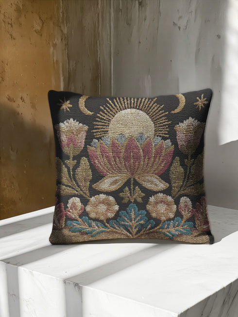 Woven tapestry pillow, 17" x 18", showcasing a radiant sun above a lotus with crescent moons and florals in gold, berry, and teal on black. Artisan-woven 58% cotton, 42% polyester; stuffed with soft polyfill. Sewn-shut construction; pattern duplicated on both sides. Luxe, symbolic woven pillow for celestial décor, dark-academia styling, and enchanting living spaces.