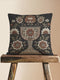 Woven tapestry pillow, 17" x 18", featuring an ornate chalice framed by botanical motifs in ivory, rust, and olive on a black ground. Artisan-woven of 58% cotton, 42% polyester and stuffed with soft, durable polyfill. Sewn shut for a smooth, seamless finish. Double-sided pattern for full visibility. Dark-academia, mystical décor accent; folklore-inspired woven pillow for sofa, chair, or bed.