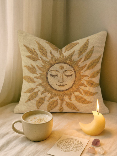 A square woven tapestry throw pillow in neutral earth tones of beige and gold. The pillow has a rich, textured surface from its jacquard weave. The design features a large, central celestial sun face with closed eyes, a serene smile, and a third eye symbol on its forehead. The sun's rays are stylized as intricate leaves, blending botanical and solar motifs. The pillow is made from a durable cotton and polyester blend, giving it a high-quality, artisanal feel.