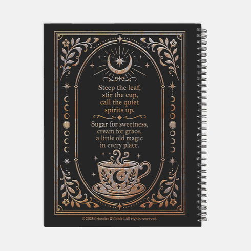Spiral-bound recipe journal with a black cover and a metallic gold and silver design. The front reads Tea Leaves and Table Spells, Recipes for Sips, Sweets and Small Magic, framed by an arch, a crescent moon and star, moon phases, botanical sprigs, and a steaming teacup. The wire-O binding runs along one edge. Inside are blank fill-in recipe pages with lines for the recipe name, kitchen of origin, prep and cook time, servings, ingredients, and instructions.