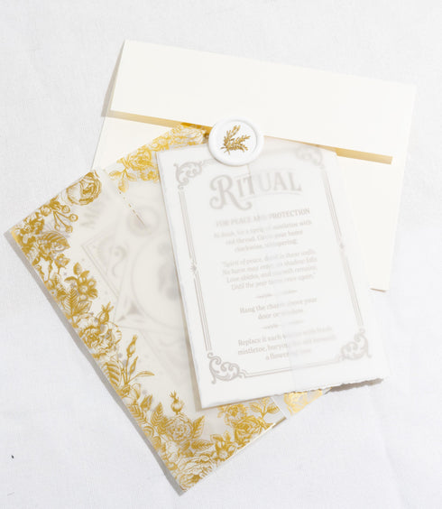 A Grimoire & Goblet luxury Mistletoe ritual card set. The 5x7 cream greeting card features gold celestial designs framing “Mistletoe” and “Love, Protection & New Beginnings.” Shown with a vellum wrap printed in gold florals, a white wax seal with mistletoe, and a premium envelope. Includes a 4x6 ritual insert on handmade deckled paper titled “Ritual for Peace and Protection.” A spiritual Yule stationery set designed as a luxurious unboxing experience.