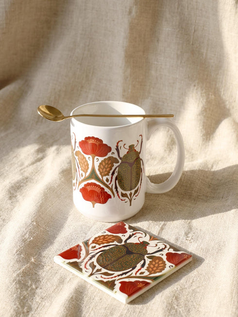A luxury gift set featuring a matching ceramic mug and square coaster with a vintage entomology design. The artwork depicts a vibrant green Scarab beetle with iridescent wings, surrounded by dark moody floral botanicals in rust and ochre, set against a creamy background in a Victorian naturalist style. The mug is 15oz with a large handle and full wrap design. The coaster is glazed ceramic tile with a cork backing. Perfect for Dark Academia and Grimoire and Goblet gothic home decor.