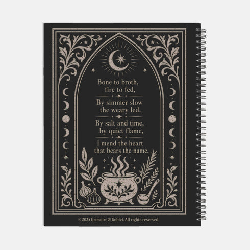 Spiral bound hardcover recipe journal lying flat. The matte black front cover is illustrated with light beige botanical vines, small crescent moons, a radial starburst, and a central cauldron releasing curls of steam, with classical lettering reading Spells of Bone and Broth. A black metal wire-o coil binds the left edge. The interior shows bright white pages printed with a structured recipe template, including labeled sections for ingredients and instructions, over a rigid chipboard backing.