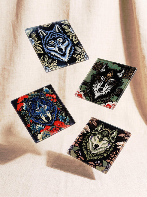 Set of 4 square tempered glass coasters featuring a mystical wolf design on a black background. High-gloss finish with non-slip rubber feet. Dark Academia and Whimsigoth aesthetic home decor. Close-up detail shows grey wolf fur texture and amber eyes. Durable drinkware protection for wooden tables. Grimoire and Goblet gothic luxury barware accessory for coffee tables and desks. Heat resistant glass surface with polished edges.