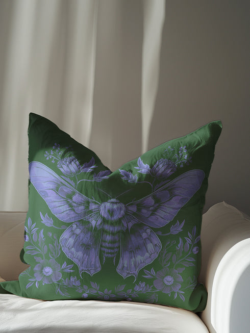 A decorative pillow cover featuring an intricate Luna moth illustration in lavender purple on an emerald green background, adorned with symmetrical botanical details and florals in a vintage naturalist style.