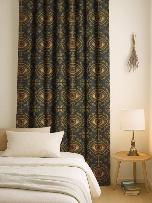 A single panel of a heavyweight blackout curtain with a rich, satiny texture. The design features a repeating pattern of a realistic, all-seeing evil eye, each framed within an ornate, golden Victorian botanical flourish on a dark charcoal background. This mystical art is ideal for Dark Academia, Gothic, and Witchy interior aesthetics, providing both a dramatic statement piece and functional light-blocking for a bedroom, library, or sacred space.