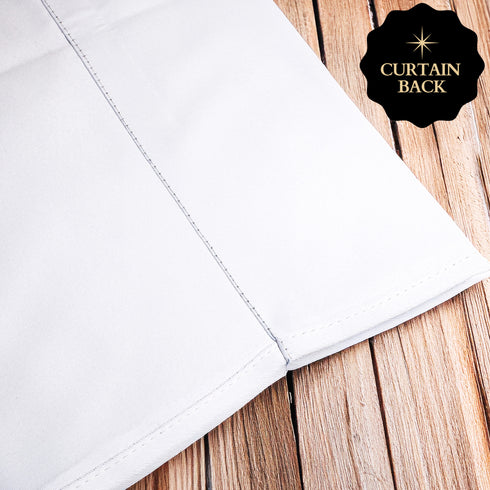 a white fabric, possibly a curtain or a sheet, placed on a wooden surface.