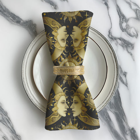 Set of four black cloth napkins with a repeating pattern of golden sun and moon faces, surrounded by swirling flames, craters, and scattered stars.