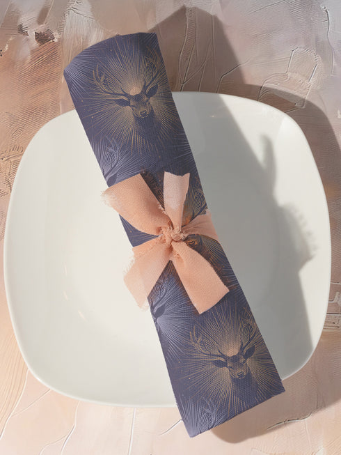 Set of four slate blue dining napkins featuring alternating gold and silver ravens in flight with botanical accents, sized 18x18 inches.