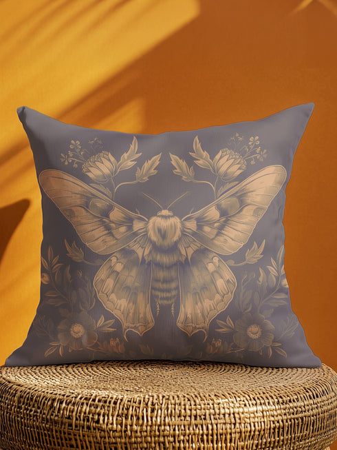 A decorative pillow cover featuring an intricately detailed Luna moth illustration in antique gold on a smoke gray background, surrounded by symmetrical botanical elements including flowers and delicate foliage.