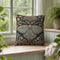 Square 17 by 18 inch jacquard woven throw pillow, woven identically on both faces and closed with a clean finished edge. A symmetrical Art Nouveau luna moth in pale sage green spreads its wings at the center of a deep teal ground. Gold scrollwork, dusty mauve palmette fans, French blue blossoms, and small cream flowers frame the moth. The design is woven flat into the cotton blend cloth, with visible thread texture across the motif and a soft sheen in the ground weave.